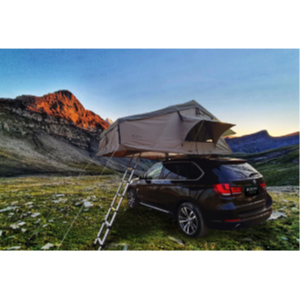 K&B Sport Deluxe rooftop tent on a dark SUV parked in a mountain valley during sunset.
