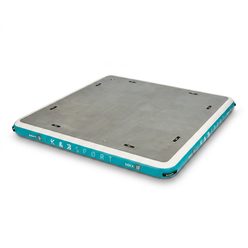 A studio product photograph is shown of the Bugatti K&B Sport inflatable floating dock, angled to the left. The grey deck, white and teal sides, and all logos and tie-down points from the reference image are visible against a pure white background with a soft shadow.