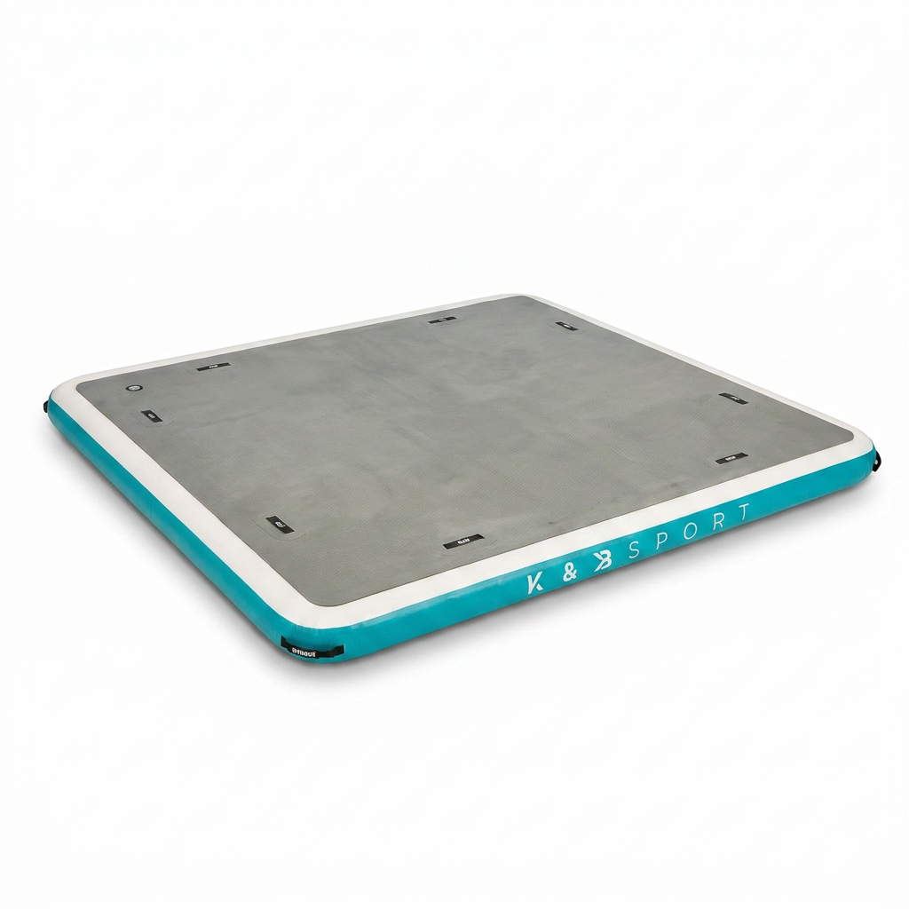 The K&B Sport inflatable floating dock, with its grey textured top, white edge, and turquoise side panels, is centered on a pure white studio background, angled to show its right side, with a soft shadow beneath it.