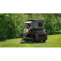 K&B Suite Hardtop Roof Tent on a black SUV in a grassy field, featuring a fiberglass shell.
