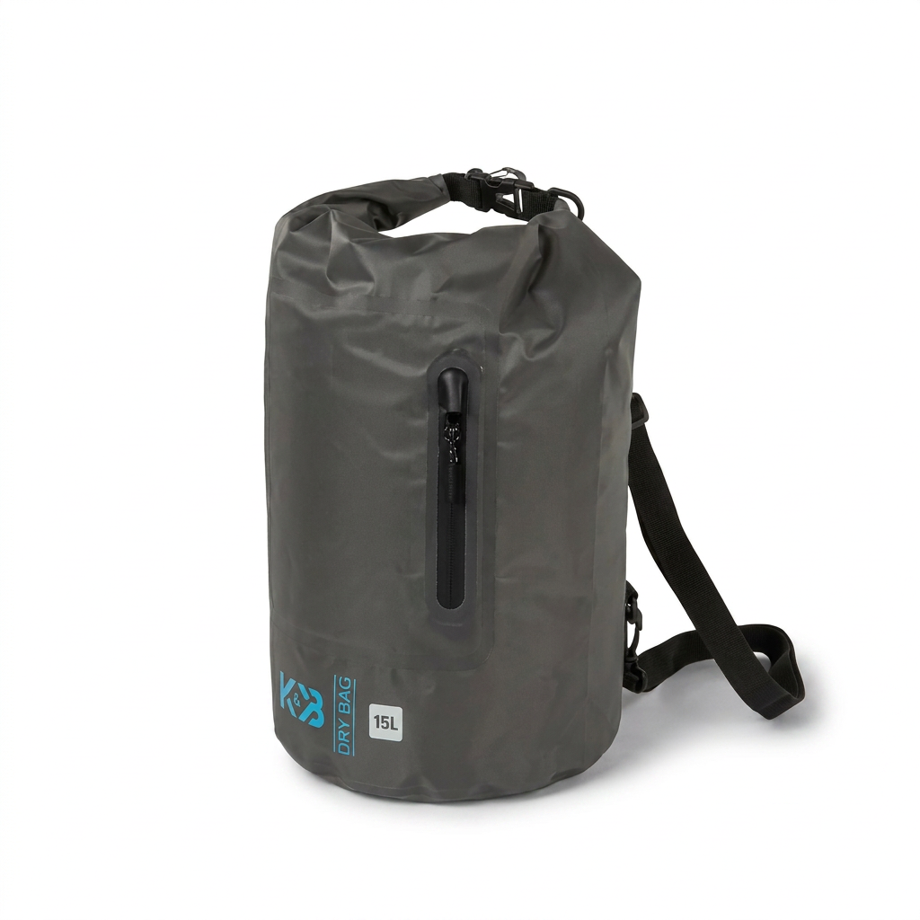 A photorealistic studio product shot of the dark grey Bugatti K&B Sport Ripon Dry bag 15L, angled to the left on a pure white background with a soft shadow. The blue logos, zipper, and strap are visible.