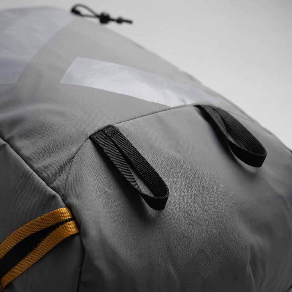 Macro view of the grey water-resistant ripstop material and sturdy black gear loops on the Bugatti Rogers Backpack.